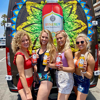 Brand mobile tour with young ladies holding Synergy Raw Kombucha